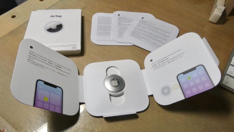 First-generation AirTag and packaging in a 2021 photograph, illustrating AirTag luggage tracking without claiming a current product test.