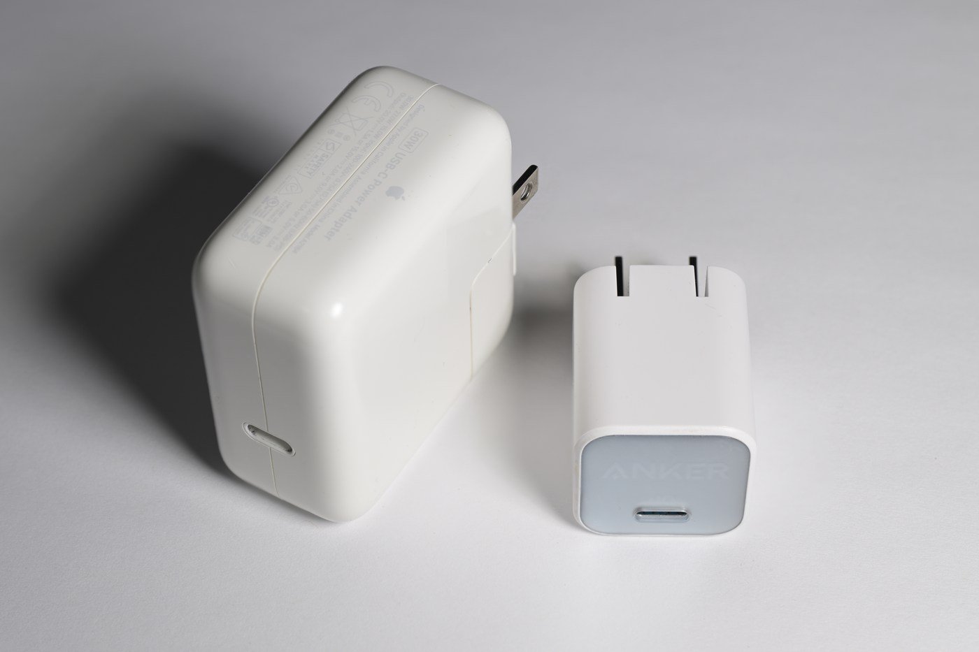 Apple 30-watt USB-C adapter beside a smaller Anker 30-watt GaN adapter, both shown as archival hardware examples.