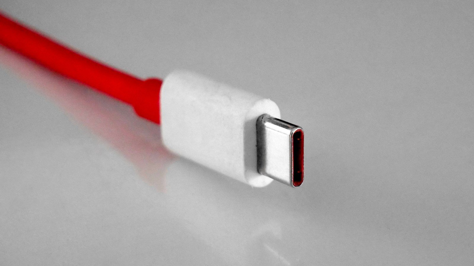 Close-up photograph of a USB-C cable plug, illustrating the connector used for USB-C laptop charging.